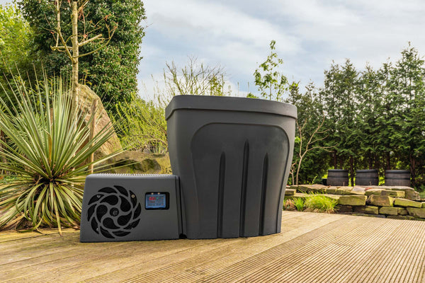 Revive Pro ice bath in sleek black design positioned on wooden deck surrounded by lush garden landscaping