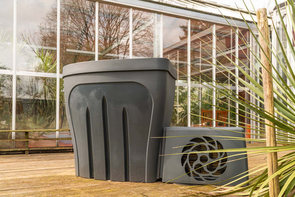 Revive Pro ice bath tub in sleek gray polyethylene with modern design, positioned on wooden deck near greenhouse and palm fronds