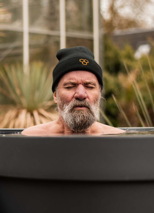 Revive Pro ice bath shown outdoors with person enjoying cold plunge therapy in modern dark-colored tub